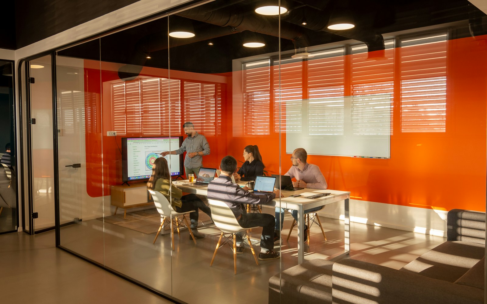 A small team working together in a modern glass-walled meeting room