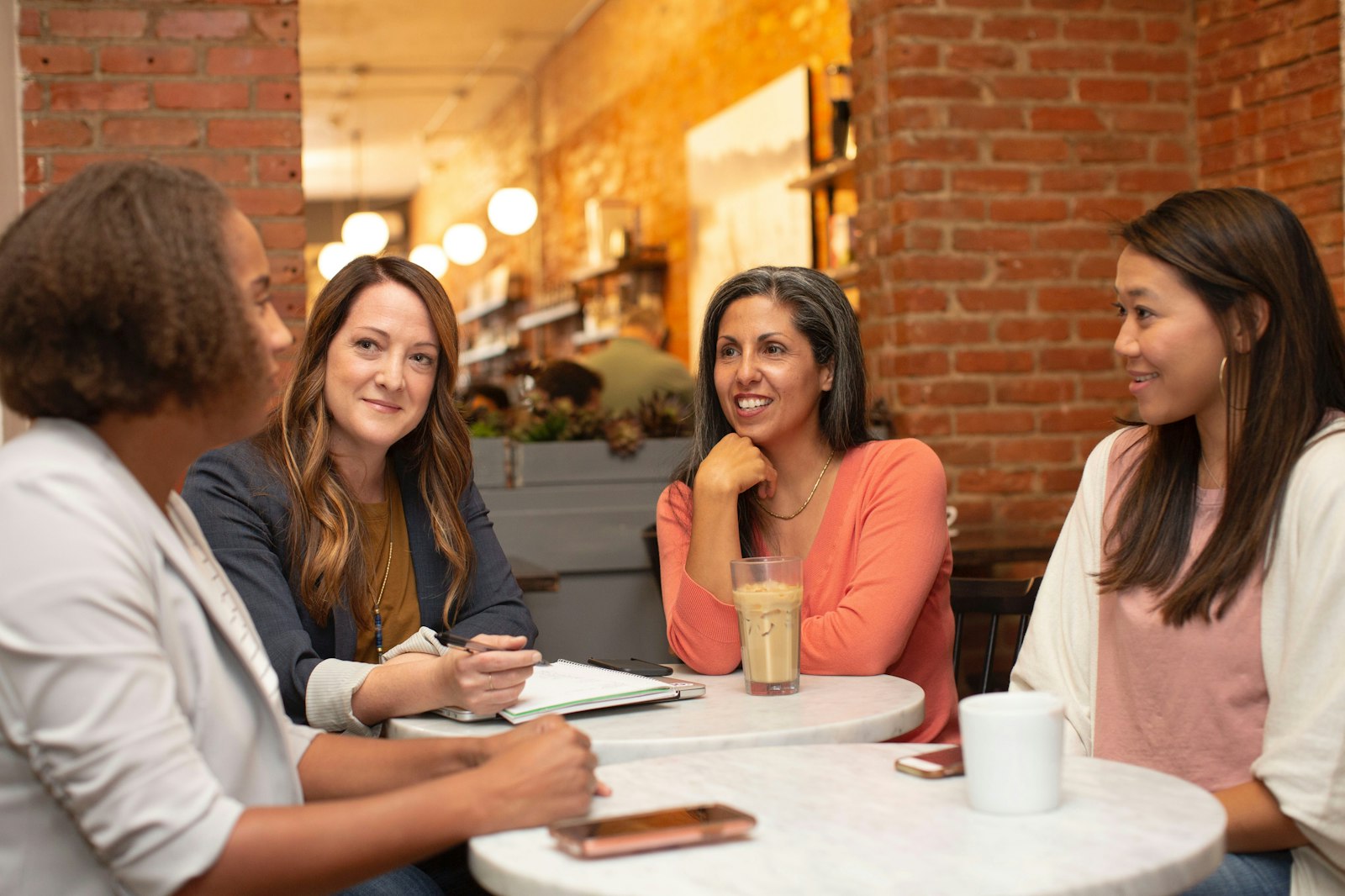 Four women of different backgrounds meeting around a table