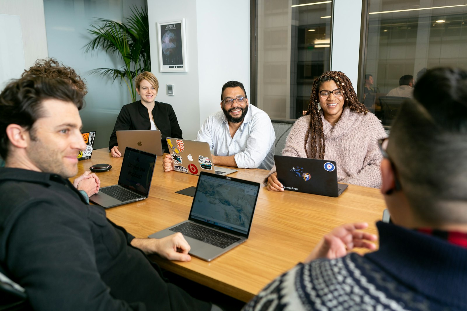 A diverse team working together around a conference table with laptops